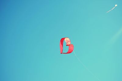 Low angle view of kite against clear blue sky