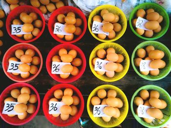 Directly above shot of eggs in bowls for sale on table at market