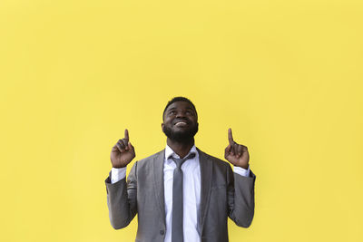 Man looking up against yellow background
