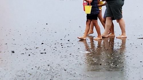 Low section of people on wet beach