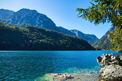 Scenic view of lake and mountains against blue sky