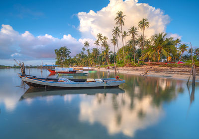 Boats moored in water against sky