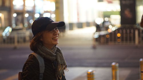 Portrait of young woman standing in city