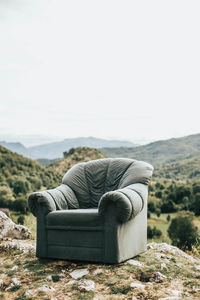 Rear view of man sitting on sofa against clear sky