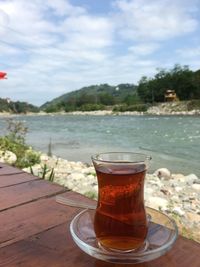Close-up of turkish tea on table by river