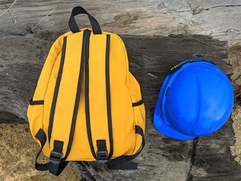 High angle view of backpack and hardhat on wood