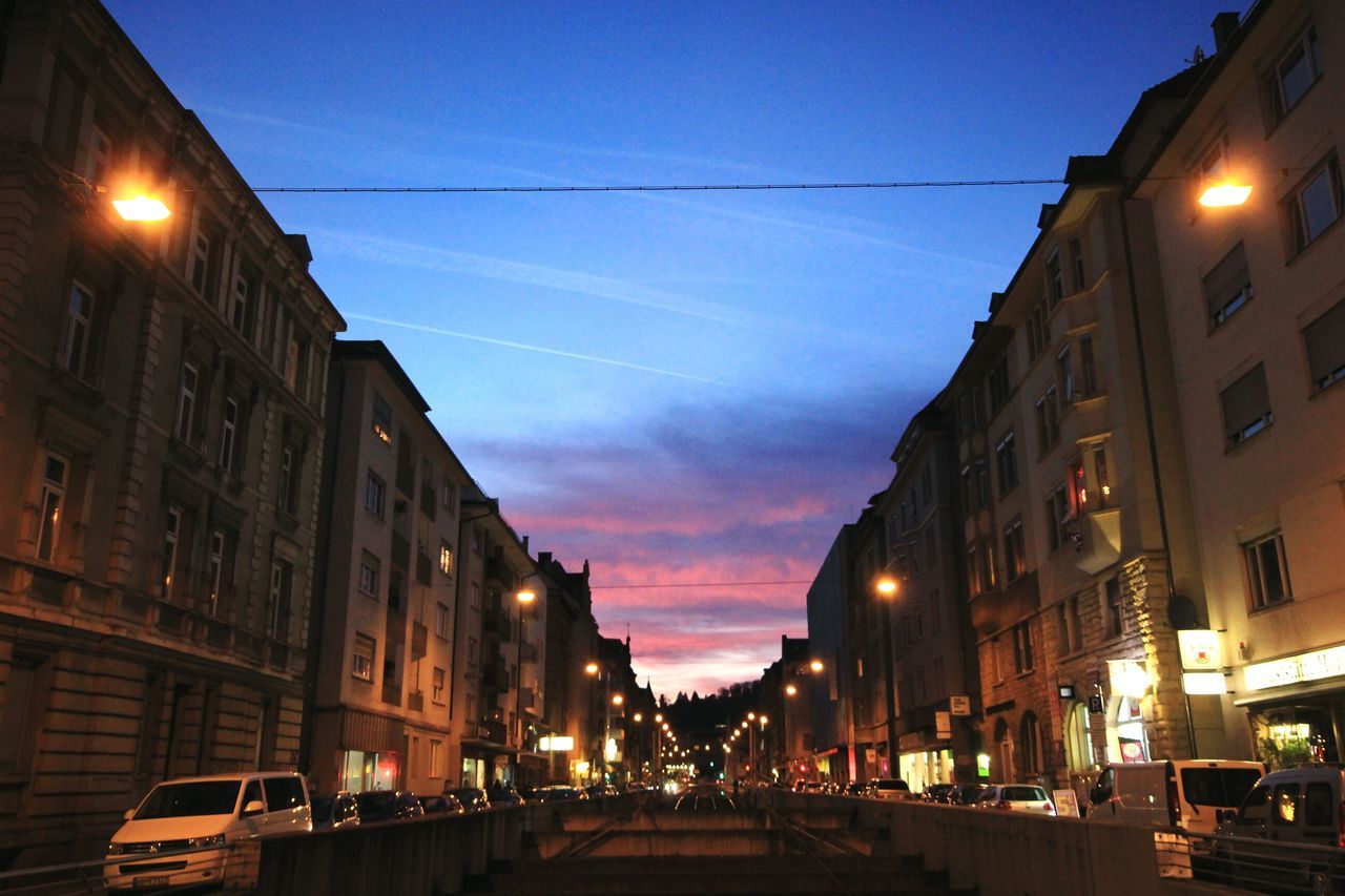 building exterior, architecture, illuminated, built structure, street light, sky, street, lighting equipment, sunset, city, transportation, power line, night, dusk, the way forward, road, car, building, residential structure, city street