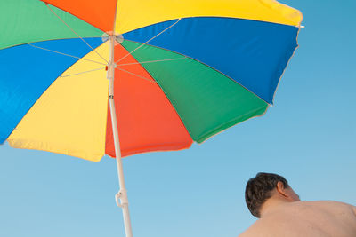 Low angle view of person against clear blue sky