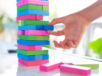 Close-up of hand holding toy on wooden table