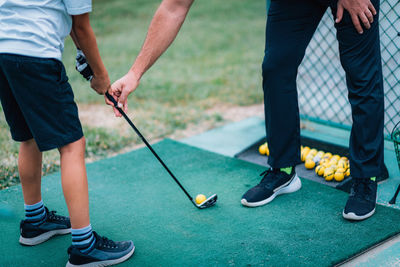 Golf personal training. golf instructor teaching young boy how to play golf. 