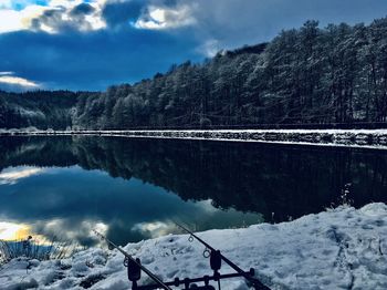 Scenic view of lake by snowcapped mountains against sky