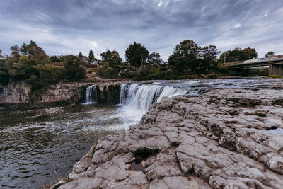 Scenic view of waterfall against sky