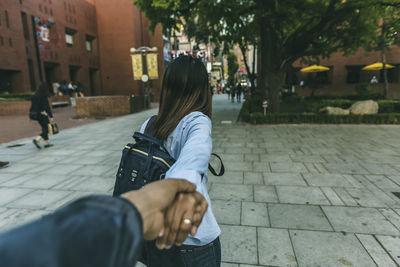 Rear view of women walking on street in city