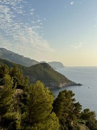 Scenic view of sea and mountains against sky