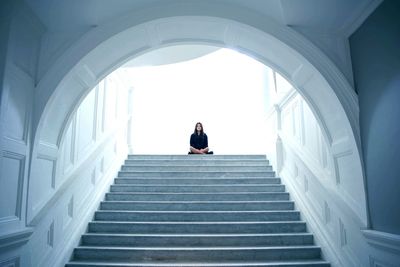 Low angle view of woman sitting on steps