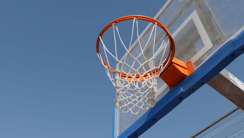 Basketball hoop against clear blue sky