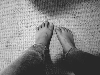 Low section of person on rug at home