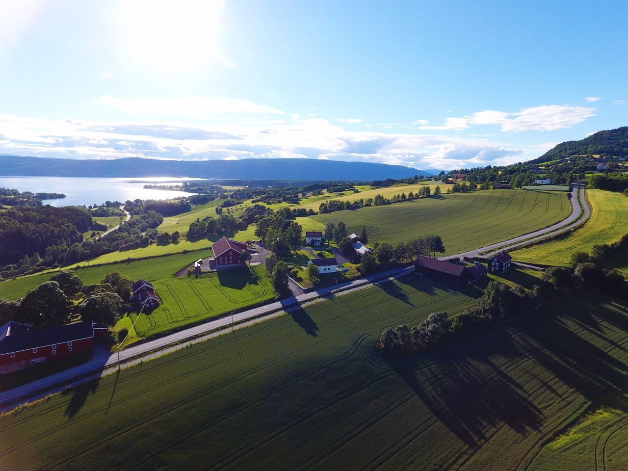 sky, sunlight, high angle view, nature, scenics, beauty in nature, built structure, tree, outdoors, no people, landscape, building exterior, day, architecture, sunbeam, mountain