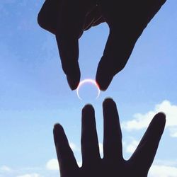 Low angle view of cropped hand against clear sky