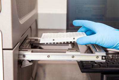 Scientist loading samples to a rt-pcr thermal cycler at the laboratory. 