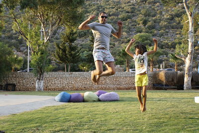 Full length of father and daughter playing on grassy field