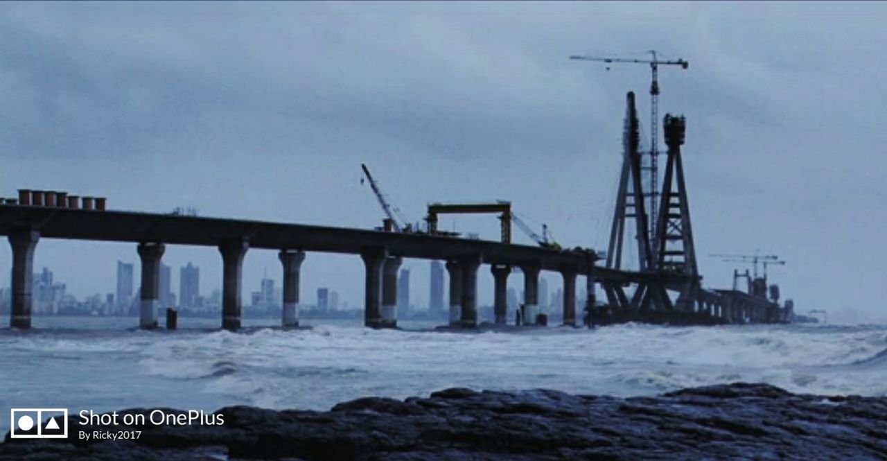 SUSPENSION BRIDGE OVER SEA AGAINST SKY