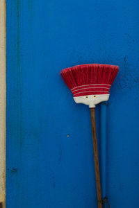 Close-up of red umbrella on blue wall