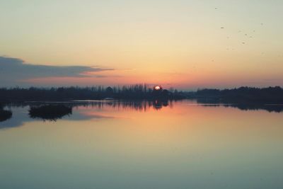Scenic view of calm lake at sunset