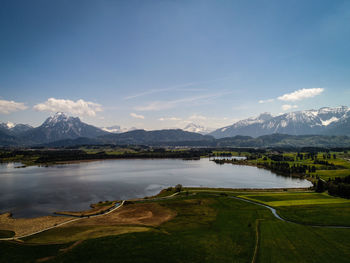 Scenic view of lake by mountains against sky