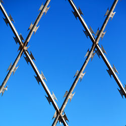 Low angle view of crane against clear blue sky