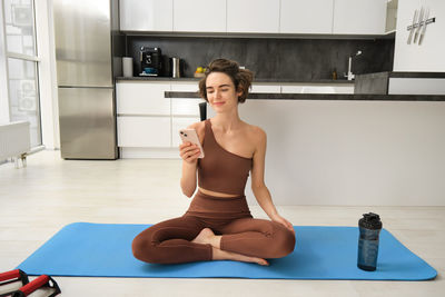 Portrait of young woman sitting on floor