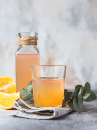 Cold and refreshing fresh orange juice in glass and bottle with fresh orange