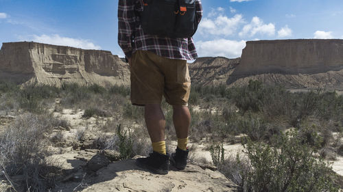 Middle-aged lone hiker walks into the distance in the desert of las bardenas reales