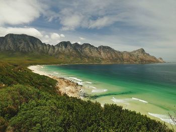 Scenic view of sea and mountains against sky