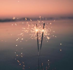 Close-up of firework display at sunset