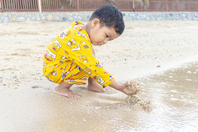 Cute boy playing with ball in water