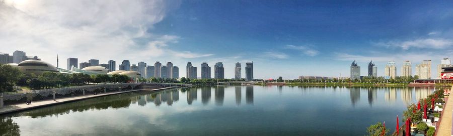 Panoramic view of lake and buildings against sky
