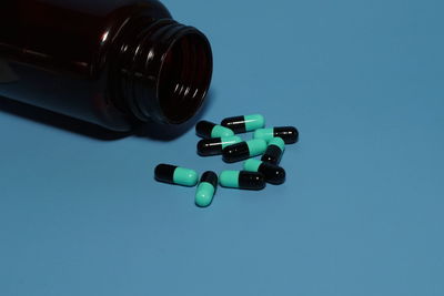 Pills with container on blue background