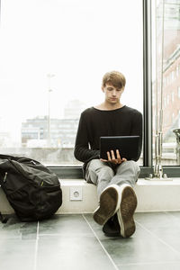 Concentrated man using laptop at railroad station