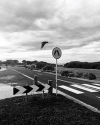 Road sign against sky