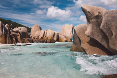 Rock formation in sea against sky