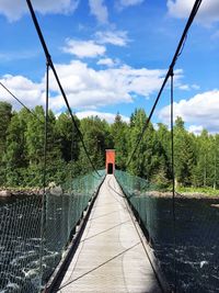 Footbridge over plants against sky