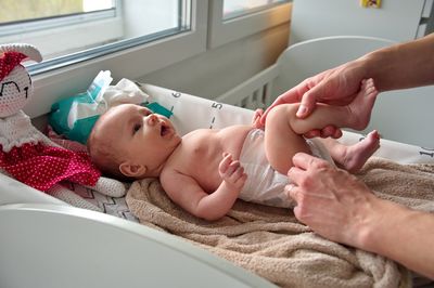 Midsection of doctor examining patient in bathroom