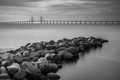 Öresund bridge over rocks in sea against sky