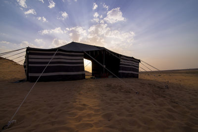 Tent on sand at beach against sky