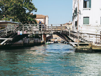 Bridge over canal against buildings in city