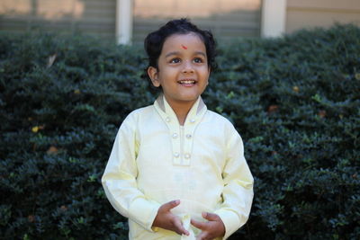 Smiling boy looking away while standing outdoors