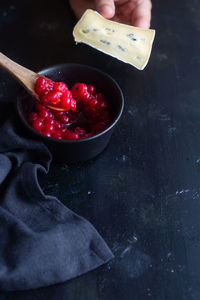 Midsection of man holding red chili peppers in bowl