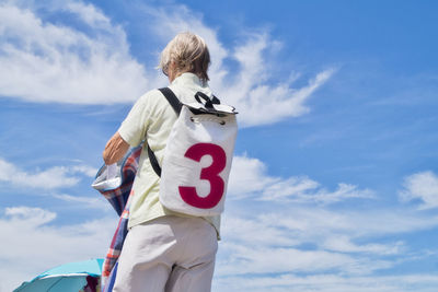 Rear view of man standing against sky