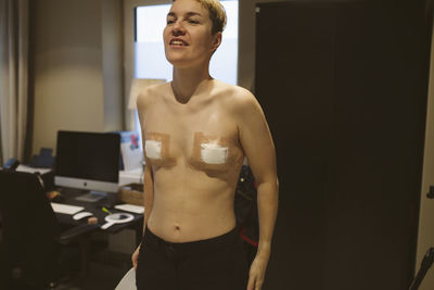 Patient after top surgery with bandages on chest